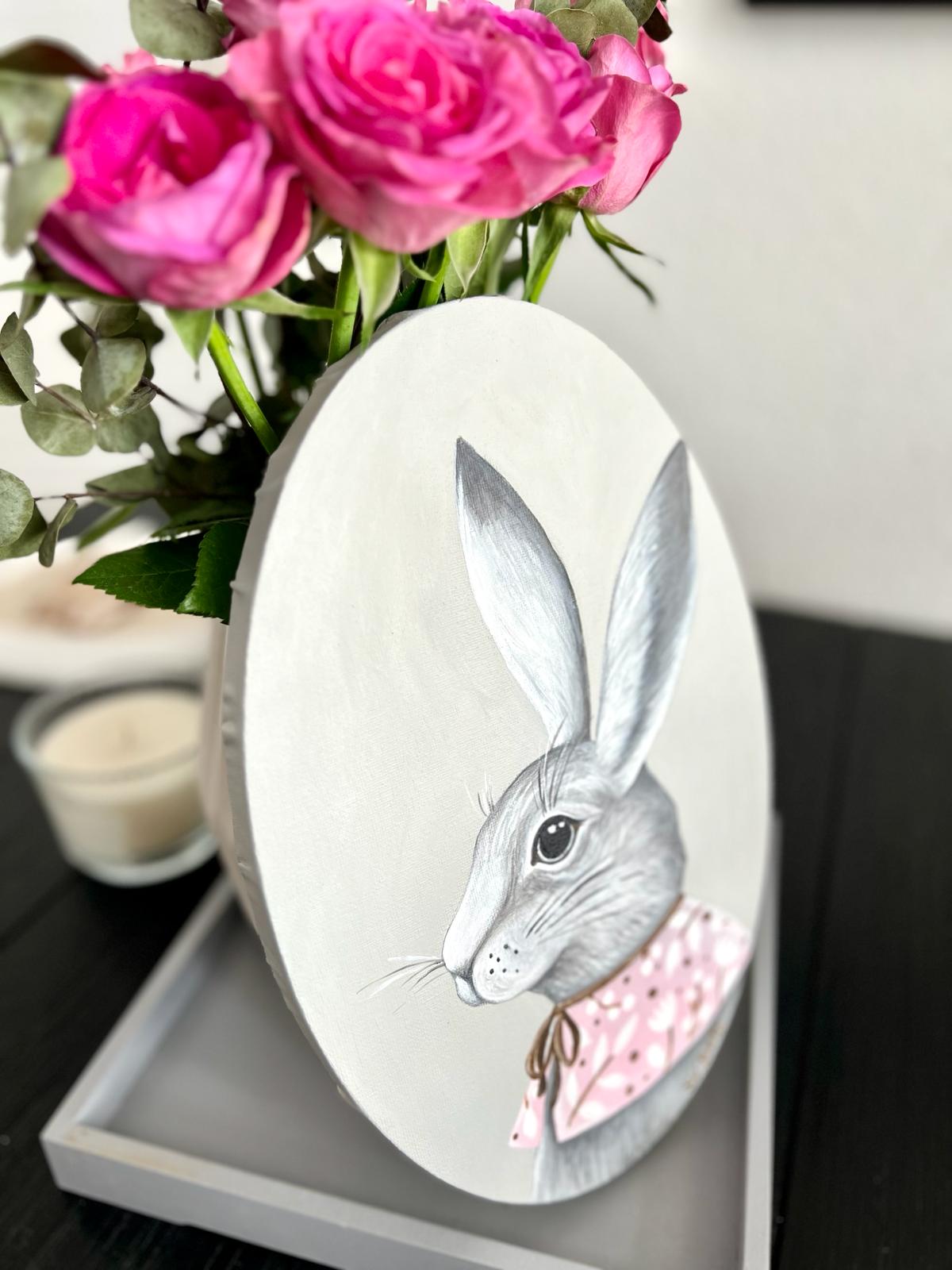 A gray rabbit with a pink collar. Acrylic painting on canvas, oval, 20*30 cm. Gift idea, wall decoration, country house decor.